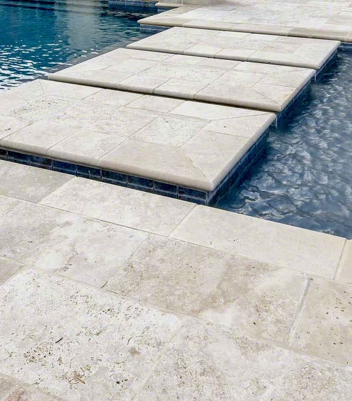 Travertine pavers stepping across a pool