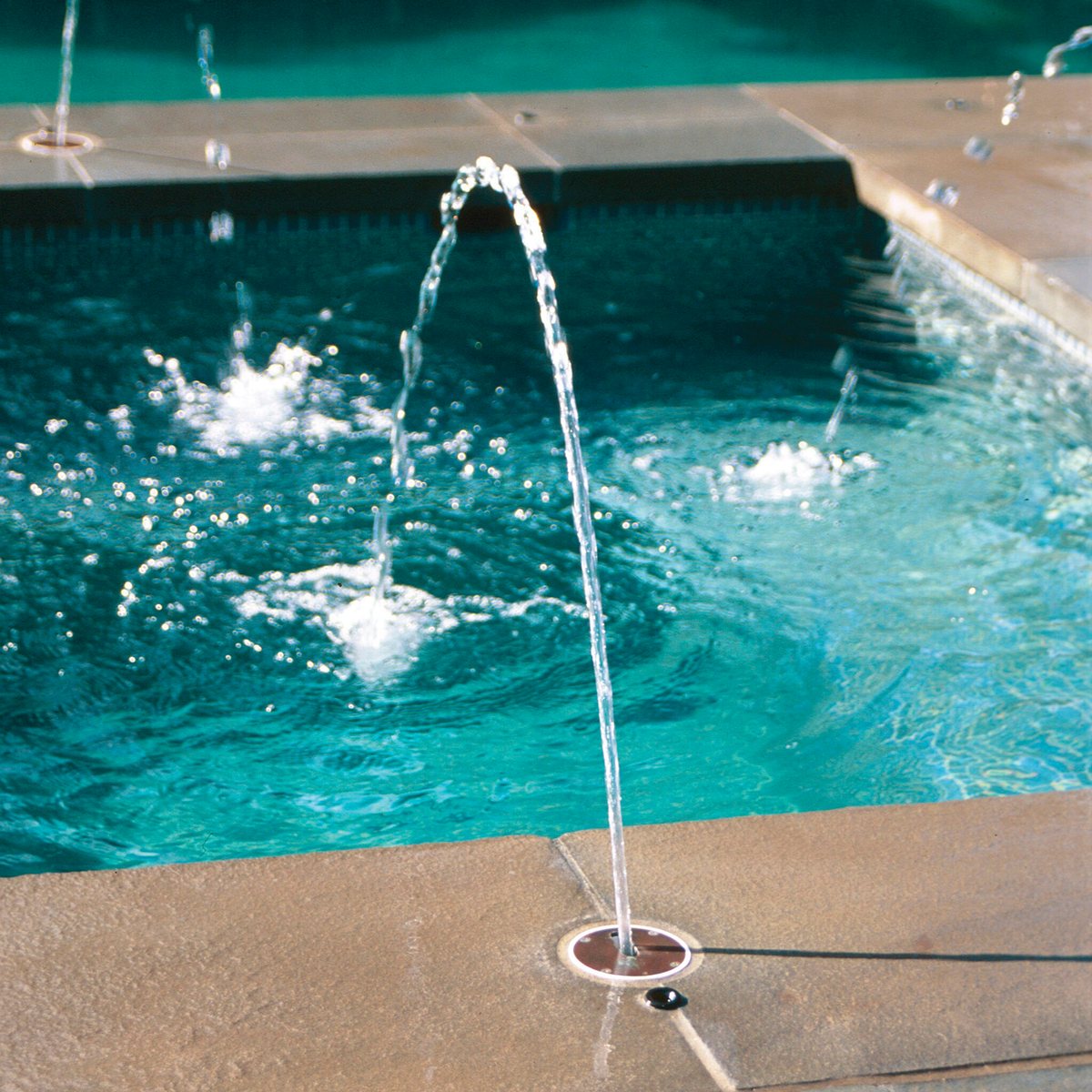 Deck jets arcing streams of water into a pool