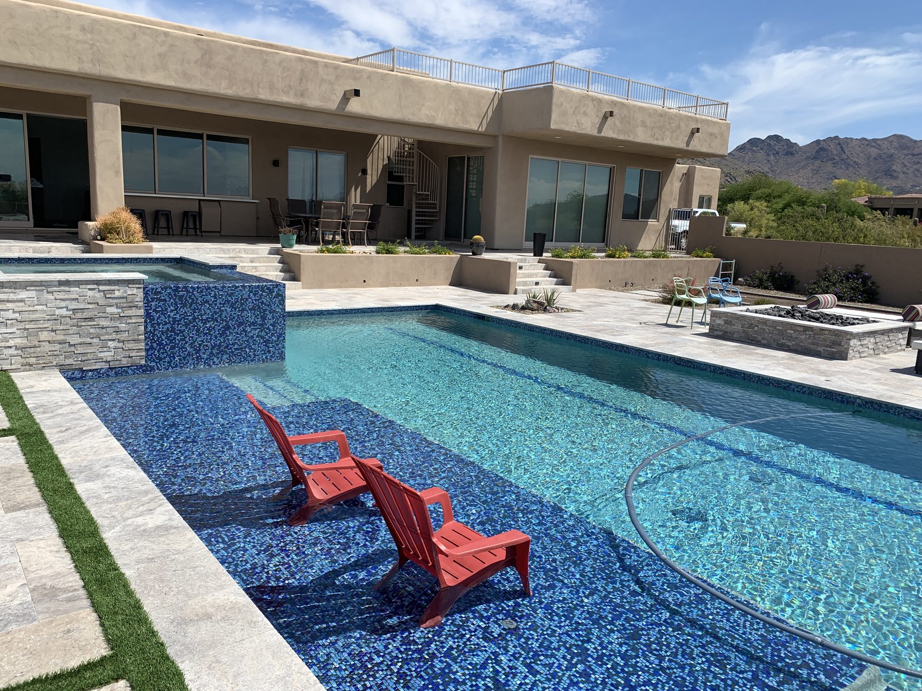 In-pool seating on a glass-tile shelf — Standard Pools project