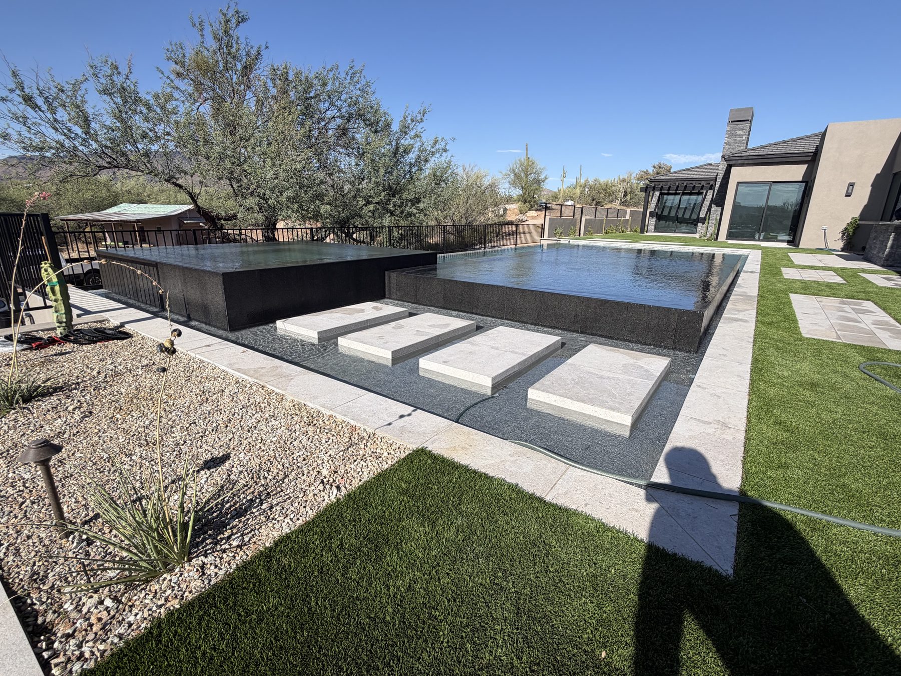 Dark tile perimeter-overflow spa edge detail — Standard Pools project