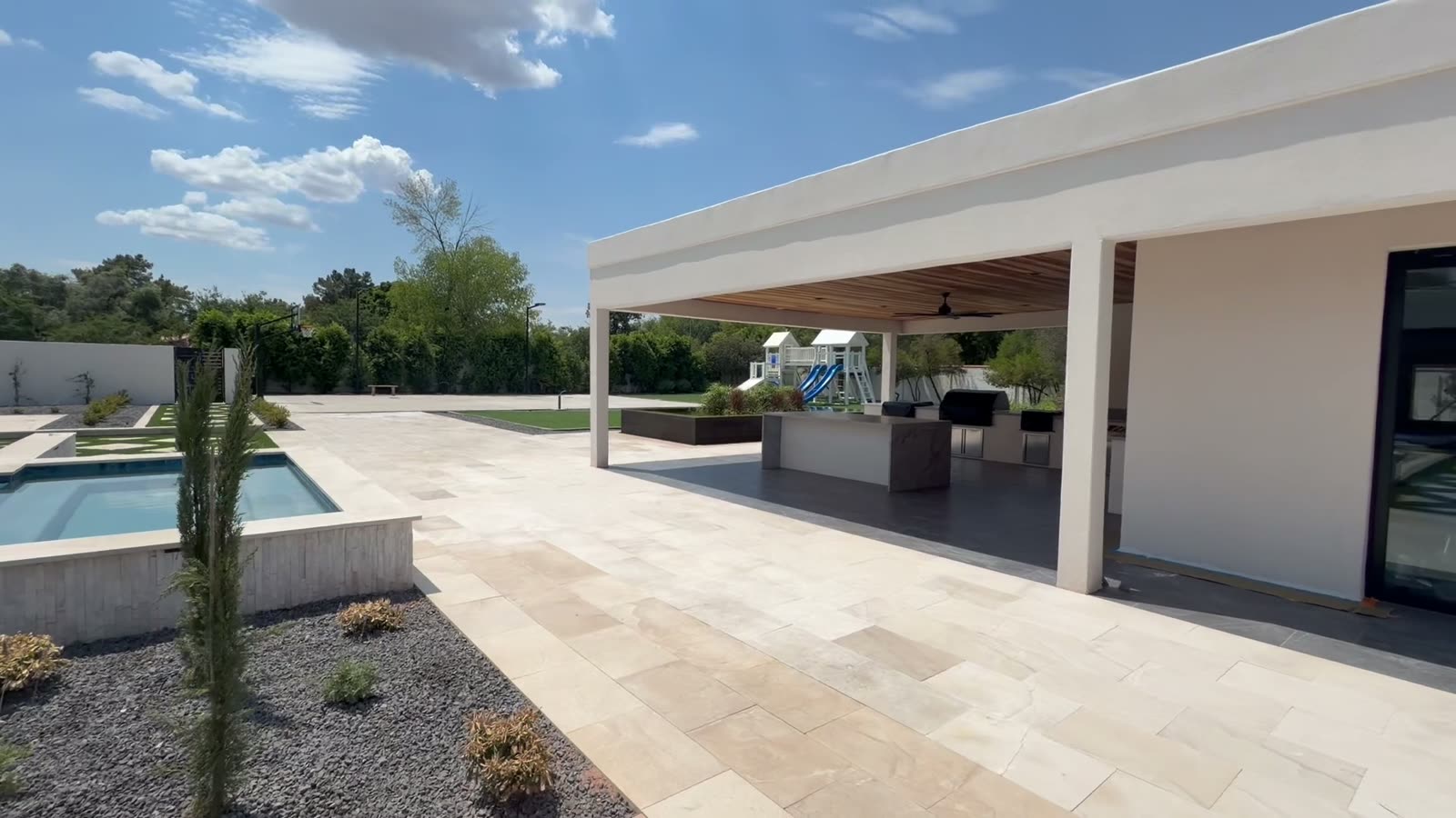White ramada with outdoor kitchen beside a pool — Standard Pools project