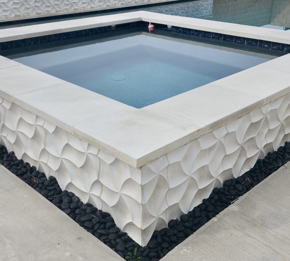 Square spa with sculpted white stone exterior